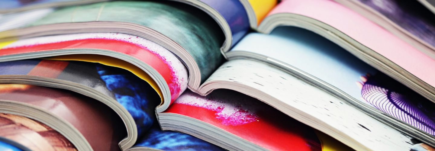 A stack of open, colourful magazines. The contents are not visible.