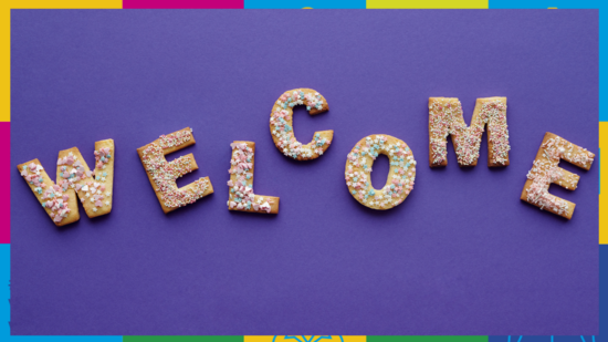 Zu sehen ist der Text "Welcome" aus Buchstaben-Keksen vor lila Hintergrund