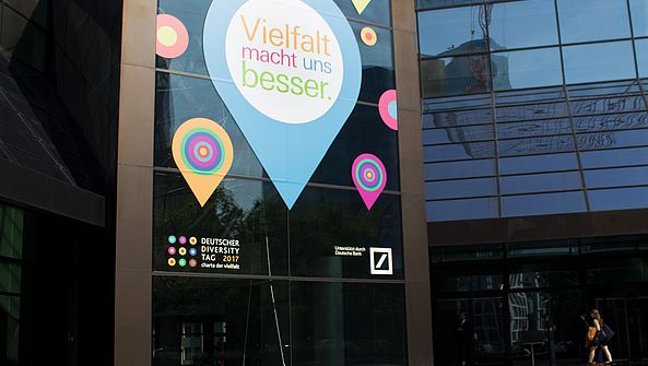 Die Glas der Deutschen Bank-Zentrale ist mit verschiedenen Logoausschnitten der Charta der Vielfalt beschmückt.