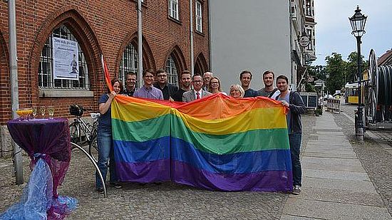 Gruppenfoto mit Regenbogenflagge